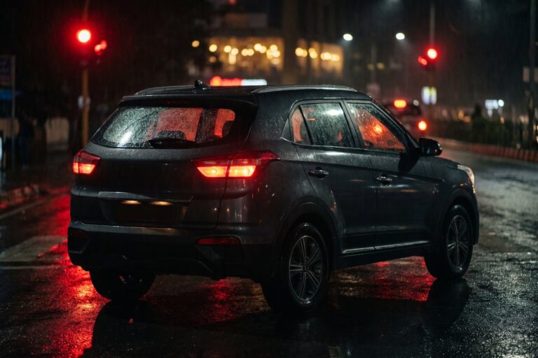 Compact SUV waiting at a signal in the rain at night