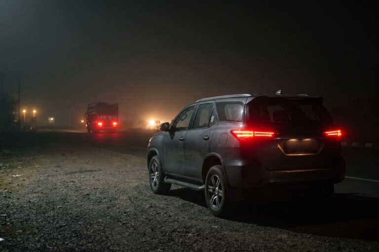Full-size SUV parked on a foggy highway shoulder at night